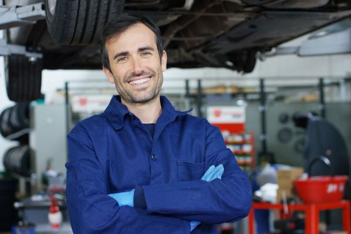 An auto mechanic smiling